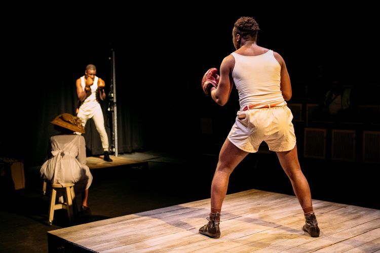 Actors in boxing costumes perform on the set of The Royale